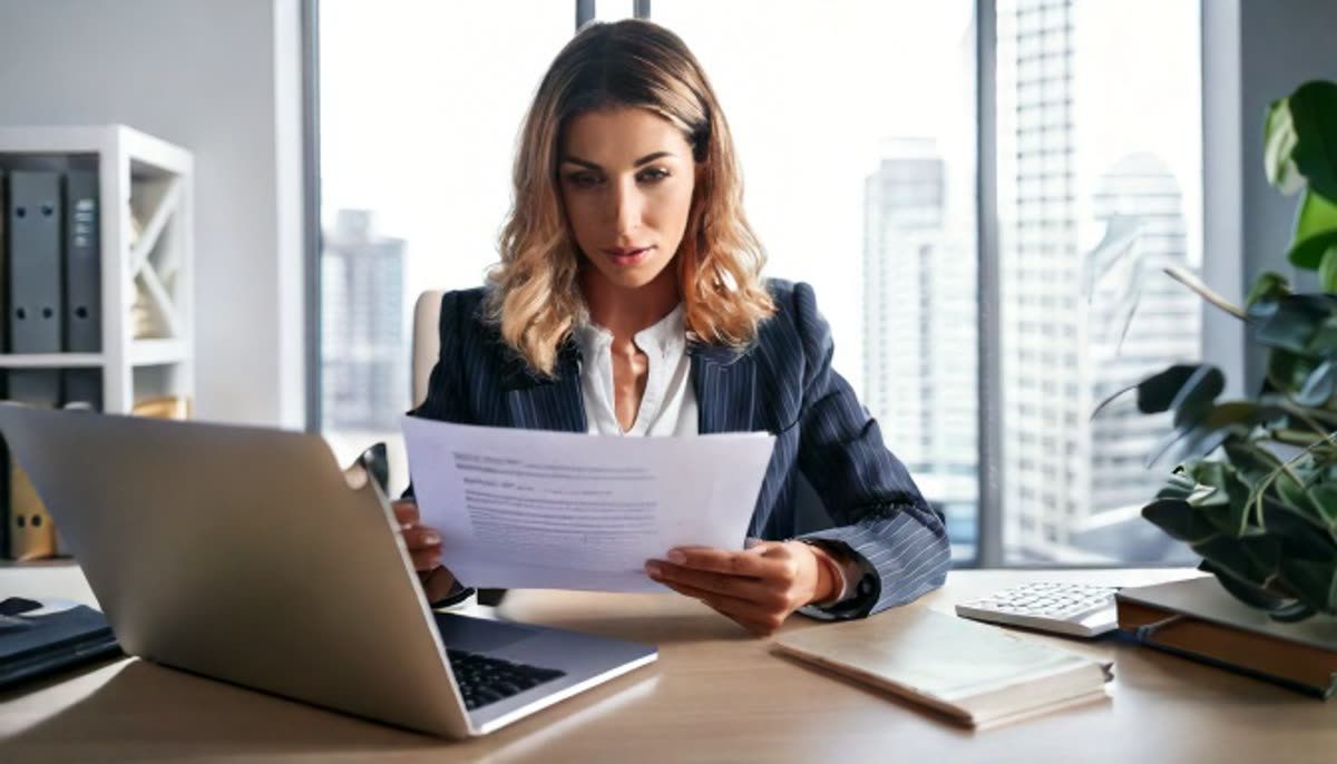 A professional reviewing a printed document at a desk