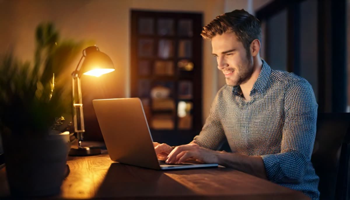 A person working focused on a laptop in a calm home office