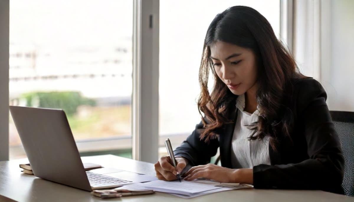 A professional signing a printed document at a desk