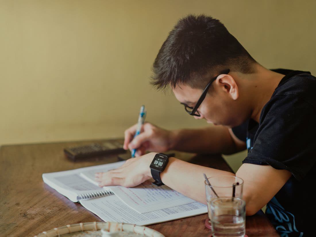 A student taking notes in a lecture