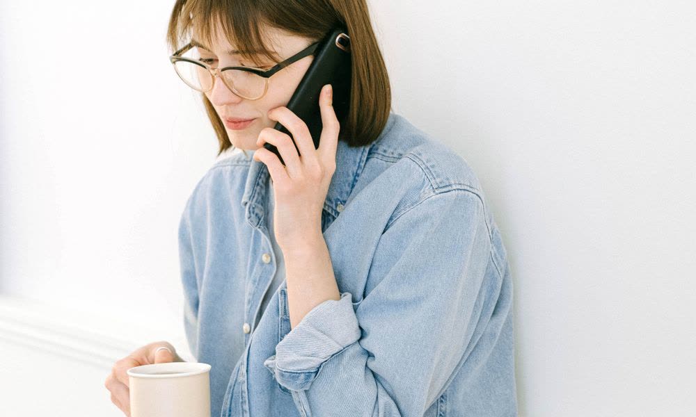 A professional taking a call at their laptop